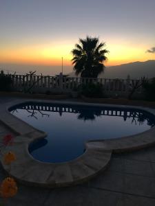a swimming pool with a sunset in the background at Casas Balcón del Mar in El Paso