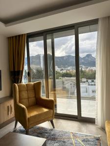 a living room with a chair and a large window at Nurel Shark Residence in Kyrenia