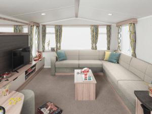 a living room with a couch and a tv at Riverside Essential Clover Caravan Pet 1 in Wooler