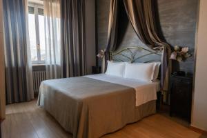 a bedroom with a bed with a large headboard at Hotel Continental in Turin