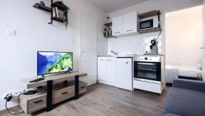a living room with a television and a kitchen at T2 Calme proche de la citadelle in Arras