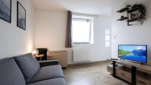 a living room with a couch and a flat screen tv at T2 Calme proche de la citadelle in Arras