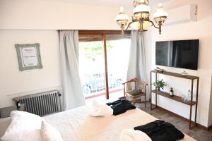 a bedroom with two beds and a flat screen tv at Castelvi casa boutique in Saladillo