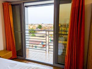 a bedroom with a large window with a view at Résidence Houé in Cotonou