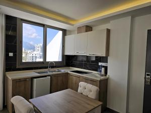a kitchen with a table and a kitchen with a window at Nurel Shark Residence in Kyrenia