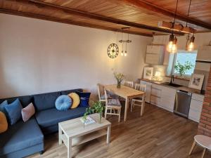 a living room with a blue couch and a table at Mazurski Apartament in Snopki