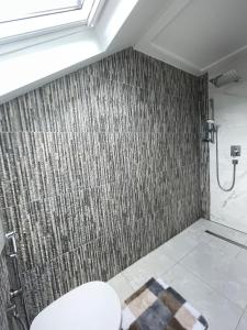 a bathroom with a shower with a tile wall at Stylish spacious residence in Düsseldorf in Düsseldorf +12 photos