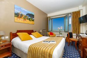 a hotel room with a bed and a desk at Hotel Aguado in Dieppe
