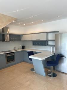 a kitchen with a counter and two blue chairs at Stylish spacious residence in Düsseldorf in Düsseldorf