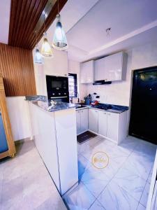 a kitchen with white cabinets and a counter top at Shelve Apartments in Aja