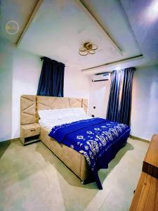 a bedroom with a bed with a blue comforter at Shelve Apartments in Aja