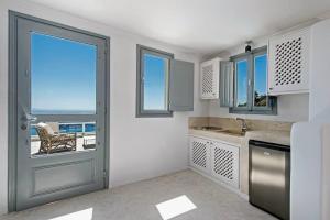 a kitchen with a door and a view of the ocean at Caldera Cliff Illusion in Fira