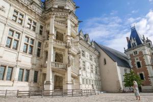 a large stone building with a tower and a church at Le Duplex Chartrain - Séjour au cœur de Blois in Blois
