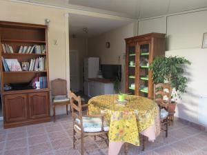 a dining room with a table and chairs and a room with a book shelf at piedameretnature in Lagord