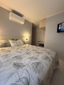 a bedroom with a white bed with a plant printed on it at Lindo Apartamento in Brasília