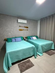 two beds sitting next to each other in a room at Casa Massa in Marechal Deodoro
