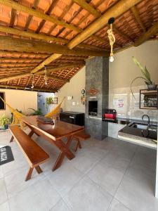 a living room with a wooden table and a kitchen at Casa Massa in Marechal Deodoro