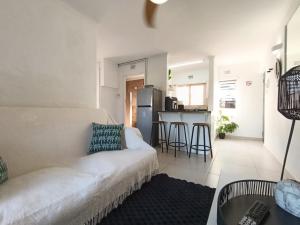 a living room with a white couch and a kitchen at Cosy Beach Cottage 52 Chaka's Rock Chalets Resort in Ballito