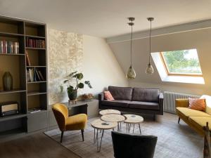 a living room with a couch and a table and chairs at Chambres d'hôtes L'Ecrin des Saveurs in Schwenheim