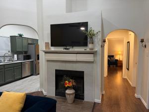 a living room with a fireplace with a tv above it at Historic Downtown McKinney 3BR in McKinney