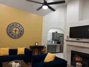 a living room with a clock and a fireplace at Historic Downtown McKinney 3BR in McKinney