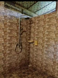 a shower in a bathroom with a brick wall at Omah Laut Bondo Jepara - by the beach, direct view of the sea, great base for water sports in Margokerto