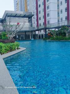 a pool of blue water in front of some buildings at Mesahill Home Stay Nilai in Nilai