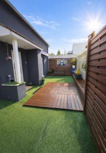 a garden with a wooden deck and grass at Le Refuge Gabriel avec grand parking privé in Blois