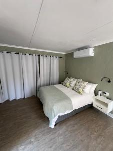 a bedroom with a large bed with white curtains at Maple and Vine in Hilton