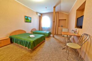 Cette chambre comprend 2 lits et une table. dans l'établissement Delta, à Kiev