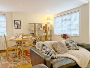 a living room with a couch and a table at Fewhurst Cottage - Billingshurst in Billingshurst