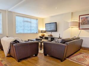 a living room with two couches and a table at Fewhurst Cottage - Billingshurst in Billingshurst