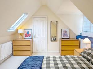 a attic bedroom with a bed and a mirror at Fewhurst Cottage - Billingshurst in Billingshurst