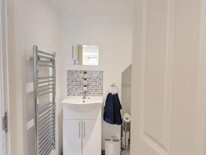 a white bathroom with a sink and a mirror at Fewhurst Cottage - Billingshurst in Billingshurst +22 photos