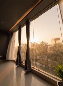 a room with a large window with a view at Noir Suites in Patna