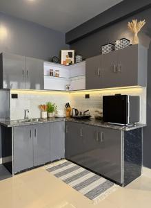 a kitchen with gray cabinets and a microwave at Noir Suites in Patna