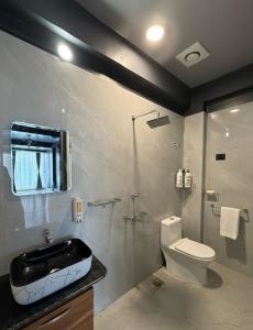 a bathroom with a sink and a toilet and a shower at Noir Suites in Patna