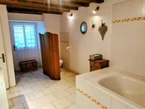 a bathroom with a large tub and a toilet at La Longère du Sallay in Saincaize-Meauce +27 photos