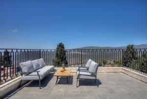 a patio with two chairs and a table on a balcony at Golden Estate - גולדן אסטייט in Safed