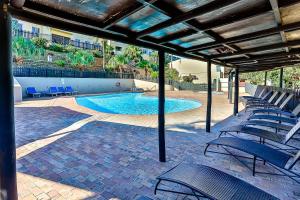 a swimming pool with blue chairs in a building at Cosy Beach Cottage 52 Chaka's Rock Chalets Resort in Ballito
