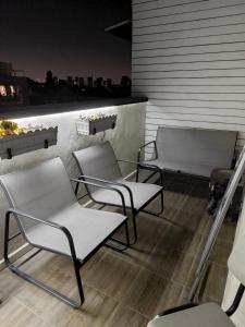 a group of chairs sitting on top of a roof at Small cozy room in a duplex in Bat Yam