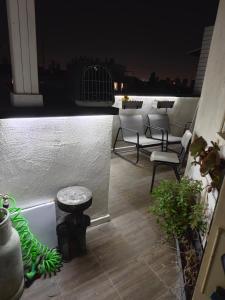 a rooftop patio at night with chairs and a table at Small cozy room in a duplex in Bat Yam +21 photos