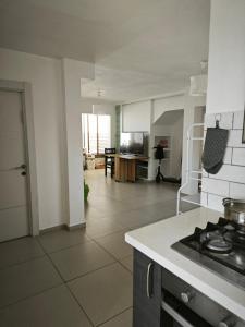 a kitchen with a stove and a living room at Small cozy room in a duplex in Bat Yam