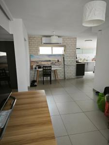 a kitchen and a living room with a table at Small cozy room in a duplex in Bat Yam
