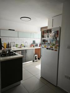 a kitchen with a white refrigerator and a stove at Small cozy room in a duplex in Bat Yam