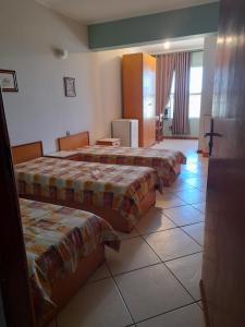 a hotel room with three beds in a room at Village Hotel in São Borja