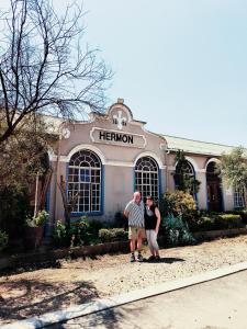 an older man and woman standing in front of a hermon building at The Hermon Hotel in Hermon