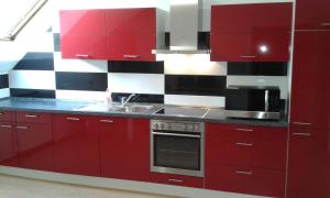 a red kitchen with red cabinets and a sink at Monteur Apartment Charlotte in Hagen