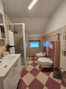 a bathroom with two toilets and a checkered floor at Apartment Čebelica in Lesce