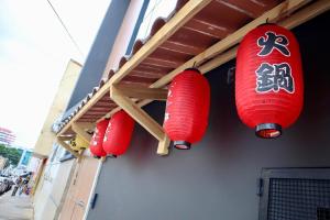 three red lanterns on the side of a building at Nihon Cápsula Hotel in Florianópolis